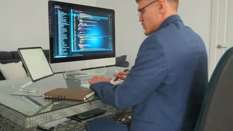 Developer codes and reviews documentation in modern office. Stock Footage 294298997