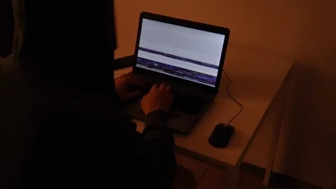 Developer coding in a dark room on a laptop when a glitch turns into code rai Stock Footage 120616466