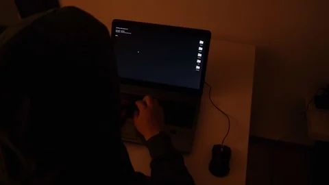 Developer coding in a dark room on a laptop when a glitch turns into code rai Stock Footage 120617459