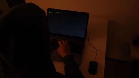Developer coding in a dark room on a laptop when a glitch turns into code rai Stock Footage 120617473