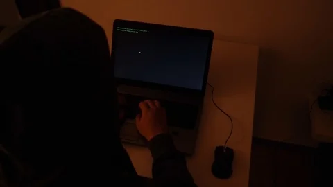 Developer coding in a dark room on a laptop when a glitch turns into code rai Stock Footage 120617524