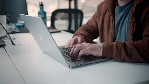 Developer coding on a macbook laptop Stockbeeldmateriaal 245735839