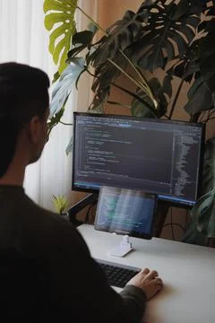 Developer is coding using screen and tablet. Freelancer is working from home Stockfoto's