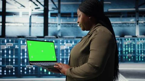 Developer in data center using green screen laptop to upgrade systems 写真素材