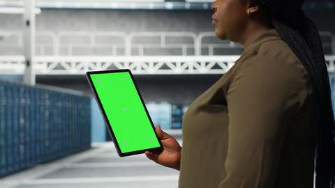 Developer in data center using isolated screen tablet to upgrade systems Stock Photos