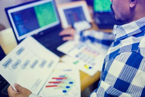 Developer is designing software on paper chart with multi computer and tablet 스톡 사진