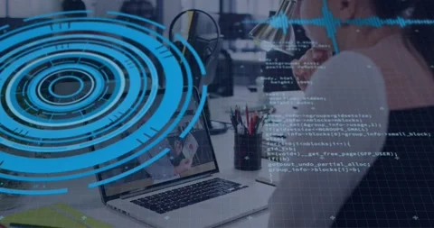 Developer at desk leaning on chin, blue HUD appearing and animating code while Stock Footage 329699934