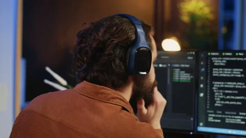 Developer drinking coffee and listening music while writing code Stock Footage 265513428