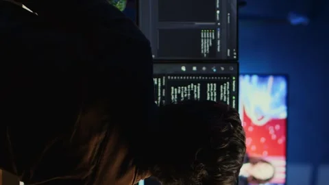 Developer drinking coffee while writing lines of code on computer Stock Footage 265107871