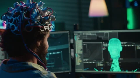 Developer with EEG headset on programming brain transfer into virtual world Stock Footage 266951518