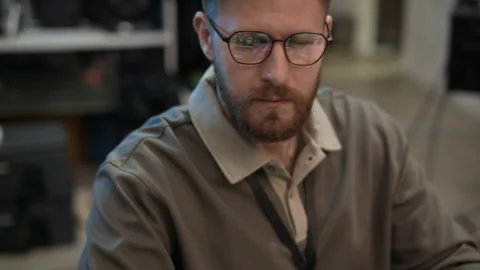 Developer in Eyeglasses Typing on Keyboard while Coding on Computer in Office Stock Footage 334933687