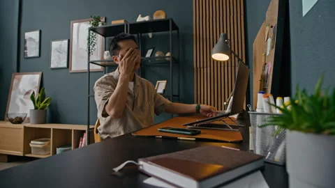 Developer Feeling Tired Sitting in front of Laptop at Table in Home Office Stock Footage 316294958