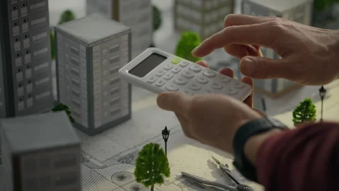 A developer focused on creating residential areas actively uses a calculator Stock Footage 275091790