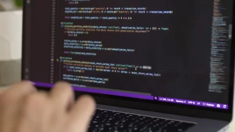Developer hands on laptop keyboard with realistic IDE code screen showing status Stock Footage 345653023