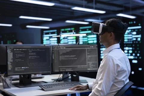 Developer immersed in virtual reality in server hub, doing units maintenance 写真素材