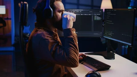Developer listening music and drinking coffee while doing programming Stock Footage 265617854