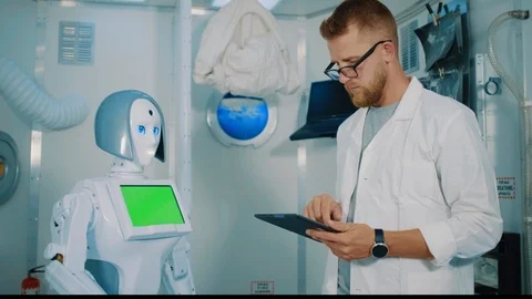 Developer man is programming humanoid robot to give five Stock Footage 123558599