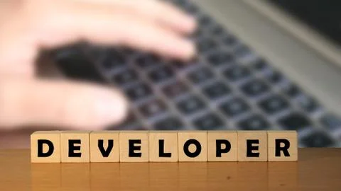 Developer message word on a wooden desk on cube blocks with a green nature ba Stockfoto's