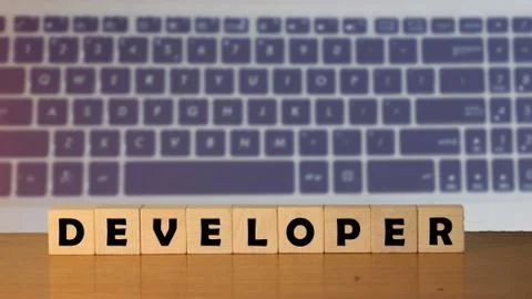Developer message word on a wooden desk on cube blocks with a green nature ba Stock Photos