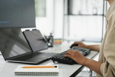 Developer programmer checking code on multiple monitor while programming to.. Stockfoto's