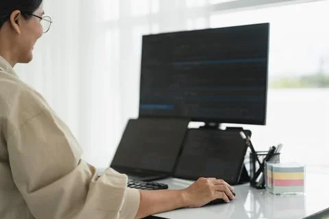Developer programmer checking code on multiple monitor while programming to.. Foto stock