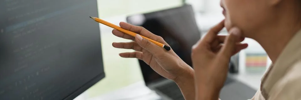 Developer programmer holds pencil and checking code on monitor while progra.. 스톡 사진