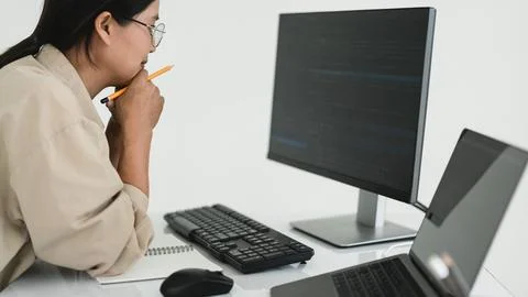 Developer programmer holds pencil and checking code on monitor while progra.. Stock Photos