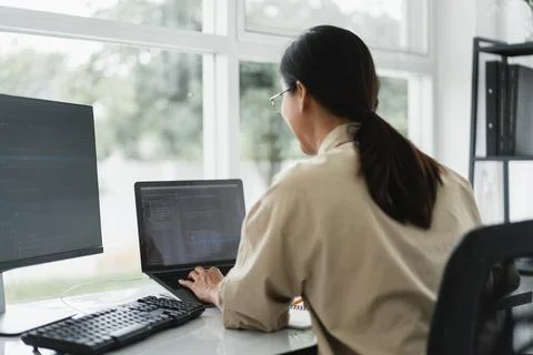 Developer programmer typing code on laptop while programming to developing .. Stockfoto's
