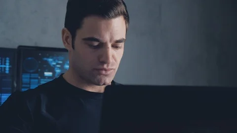 Developer programmer working on computer in a data center filled with monitor Stock Footage 102063157