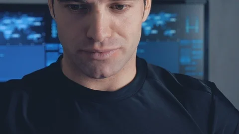 Developer programmer working on computer in a data center filled with monitor Stock Footage 102130769