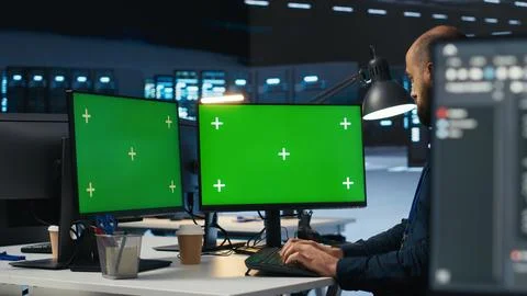 Developer programming on multi monitor isolated screen PC setup in data center Stock Photos