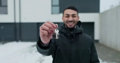 The developer, a real estate agent stands in front of a house for sale and shows Stock Footage 261537039