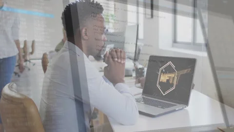 Developer sitting at open?plan office, studying glowing NFT graphic with 스톡 동영상 307433651