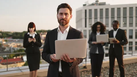 Developer smiling at camera and partners working on gadgets Stock-Footage 246117205
