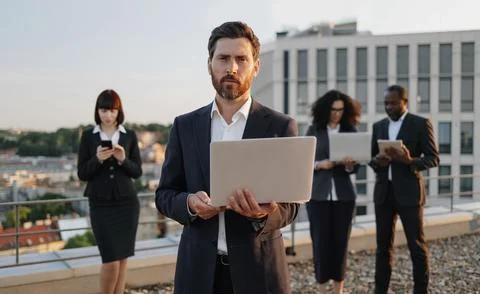 Developer smiling at camera and partners working on gadgets Foto stock