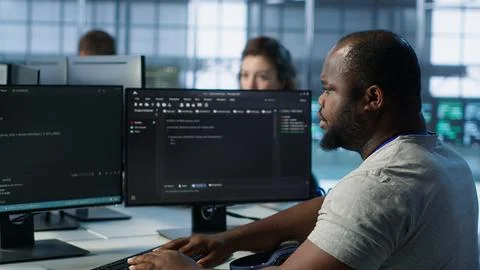 Developer suffering from cold, coughing while typing code on PC in data center Stock Photos