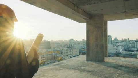 Developer in suit with a building plan on a construction site Stock Footage 74605421