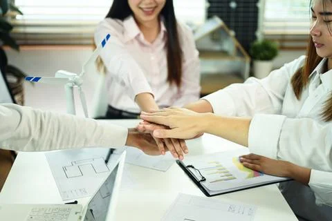 Developer team stacking hands together celebrating completion of project Stock Photos