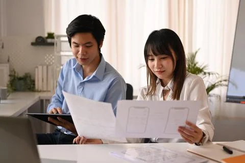 Developer team working on mobile application software design project together at Stock Photos