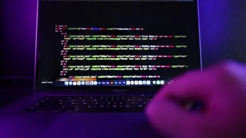 A developer typing and scrolling in a modern dark office. Stock Footage 336548328