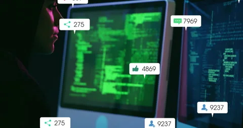Developer typing code starting social metrics icons floating on dual monitors Stock Footage 314742079