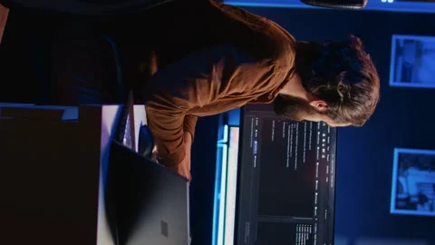 Developer typing complex code in neon lit home office, listening music Stock Footage 265108546