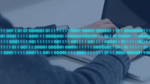 Developer typing keys, causing cyan binary stream forming over hands and Stock Footage 335235363