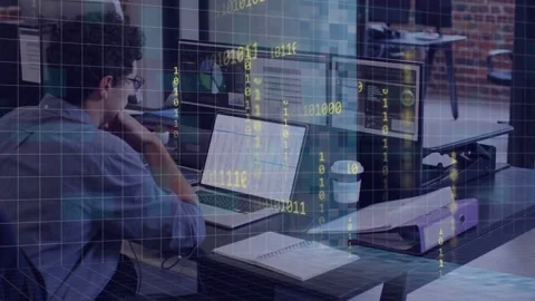 Developer typing on laptop and starting grid overlay over monitors while Stock Footage 334465861