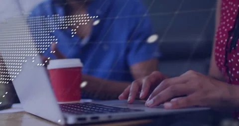 Developer typing laptop commands overlaying map while colleague watching 動画素材 309872706