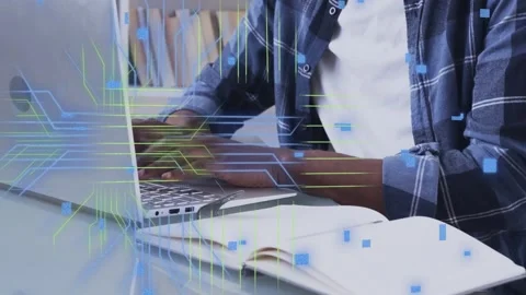 Developer typing on laptop, referencing open notebook for coding, causing code Stock Footage 335739586