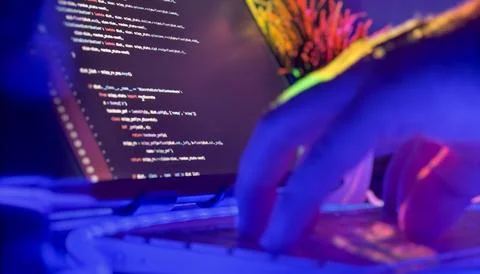 Developer typing Python code in neon-lit workspace Stock Photos