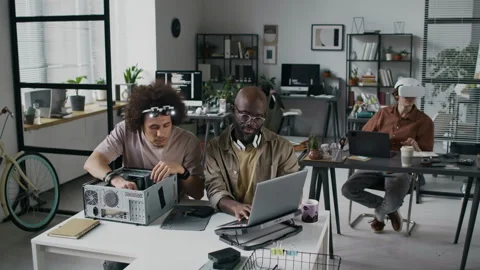 Developer Using Laptop to Help Young Colleague who Assembling Computer Case Stock Footage 299251708