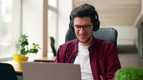 Developer, video editor man in headphones working with laptop at spacious Stock Footage 217733485