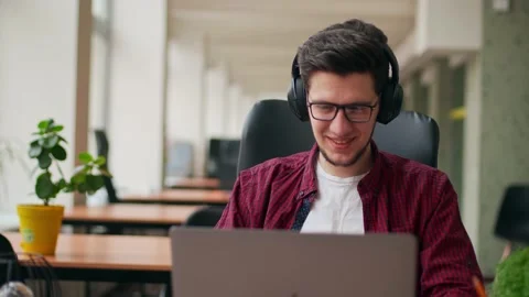 Developer, video editor man in headphones working with laptop at spacious Stock Footage 219694072